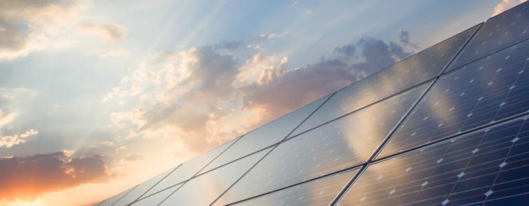 Solar panels with clouds in the background.